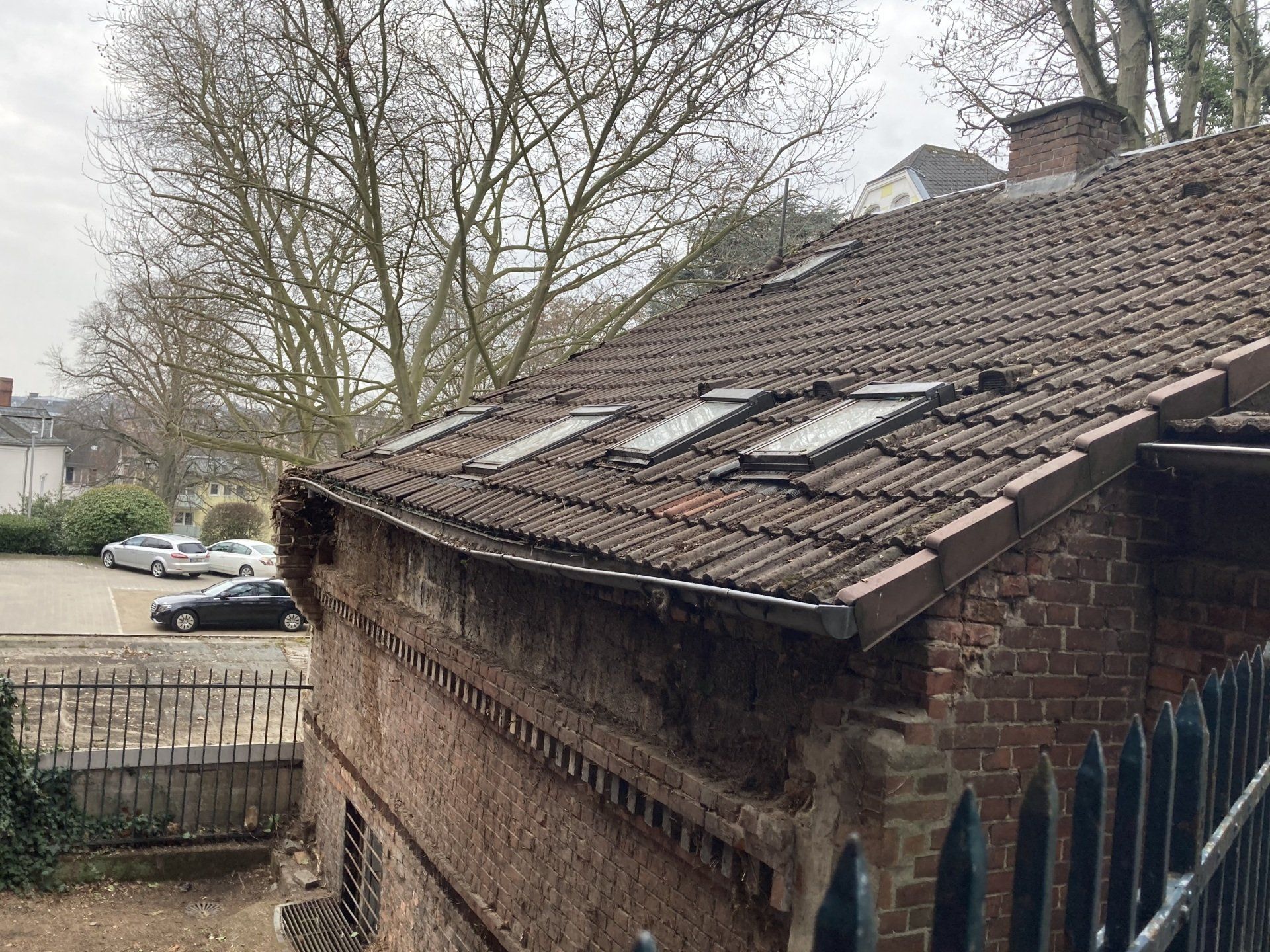 Altes Dach vor der Sanierung mit bemoosten Ziegeln